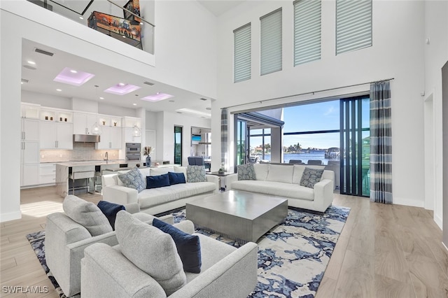 living room featuring light hardwood / wood-style flooring and a high ceiling