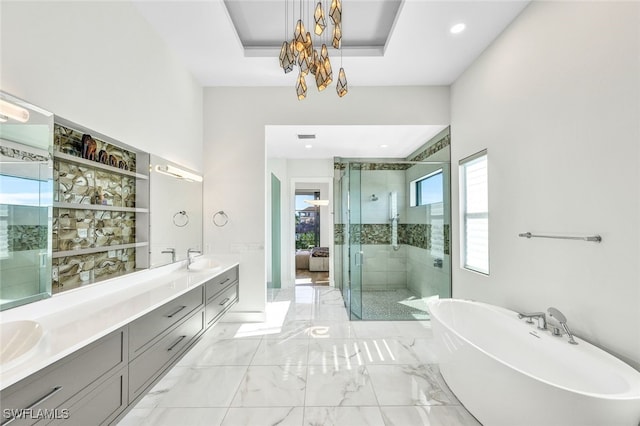 bathroom with an inviting chandelier, vanity, a raised ceiling, and shower with separate bathtub