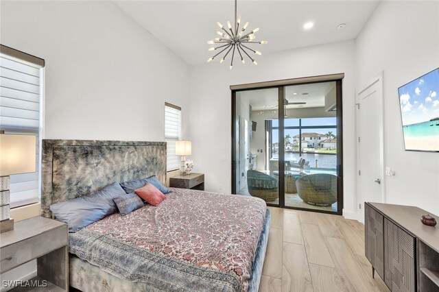 bedroom featuring a notable chandelier, light hardwood / wood-style flooring, and access to outside