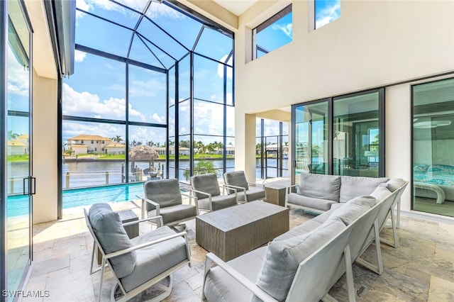 view of patio / terrace with outdoor lounge area, a lanai, and a water view