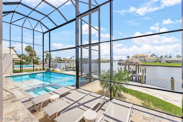 view of swimming pool with an in ground hot tub, a lanai, a water view, and a patio