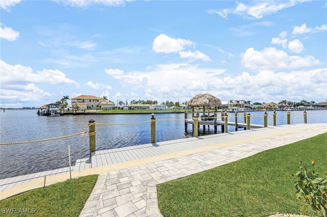 dock area with a water view and a yard