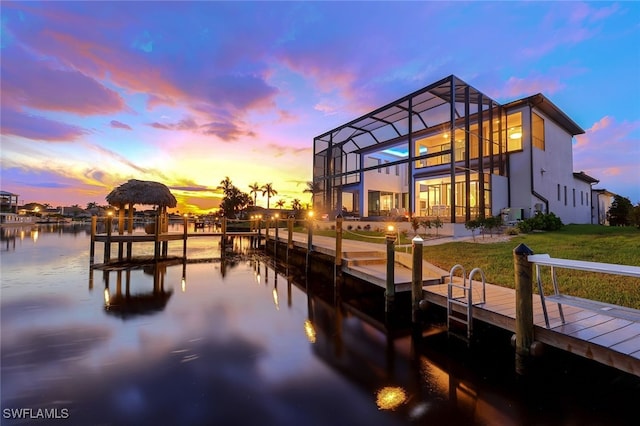 view of dock featuring a lawn, a gazebo, a lanai, and a water view