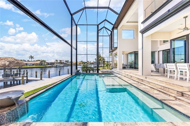 view of pool featuring a patio, pool water feature, glass enclosure, a water view, and ceiling fan