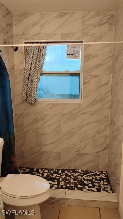 bathroom featuring tile patterned flooring, toilet, and a shower with shower curtain