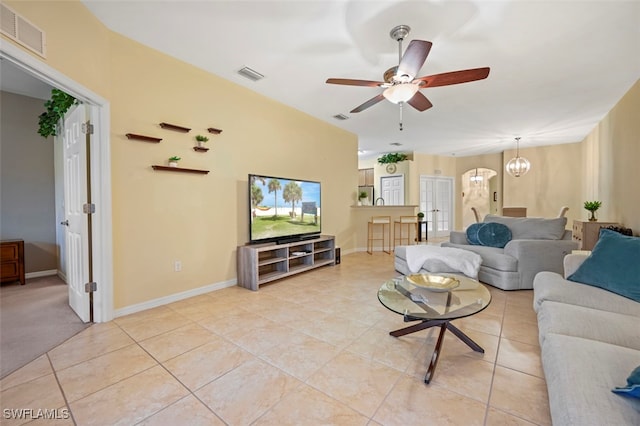 living area with visible vents, baseboards, light tile patterned flooring, and ceiling fan with notable chandelier