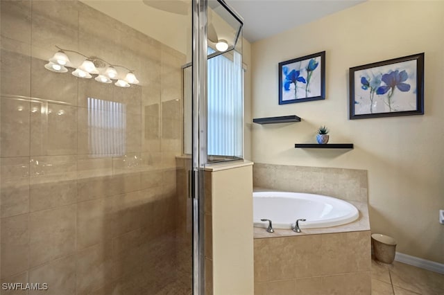 bathroom with a bath, tile patterned flooring, a stall shower, and baseboards