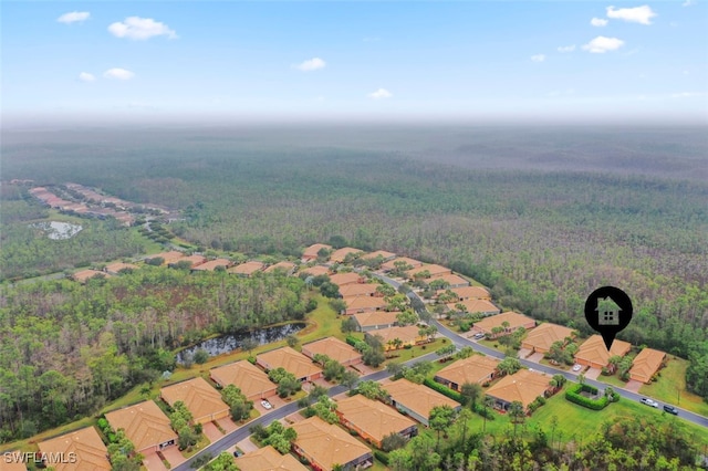 birds eye view of property with a wooded view and a water view