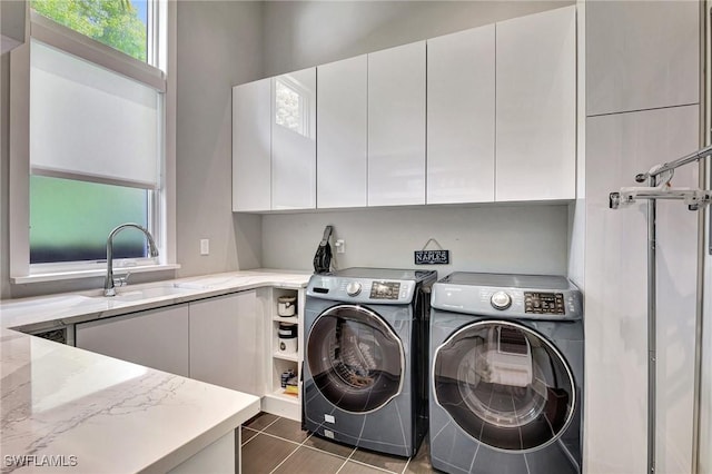 laundry room featuring cabinets, sink, washer and clothes dryer, and dark tile patterned floors