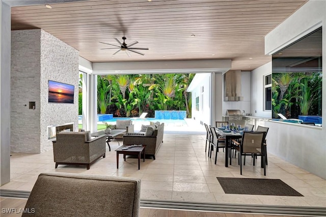 view of patio / terrace with grilling area, ceiling fan, an outdoor living space, exterior kitchen, and a swimming pool