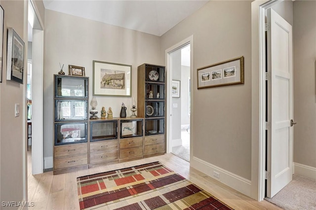 corridor with hardwood / wood-style flooring