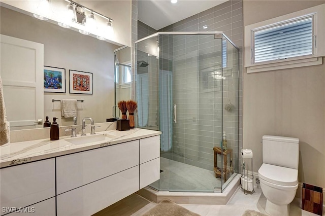 bathroom featuring vanity, tile patterned flooring, a shower with door, and toilet