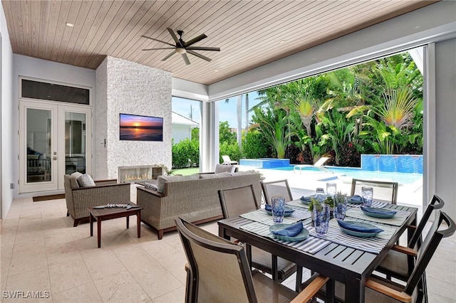 view of patio featuring ceiling fan and an outdoor living space with a fireplace