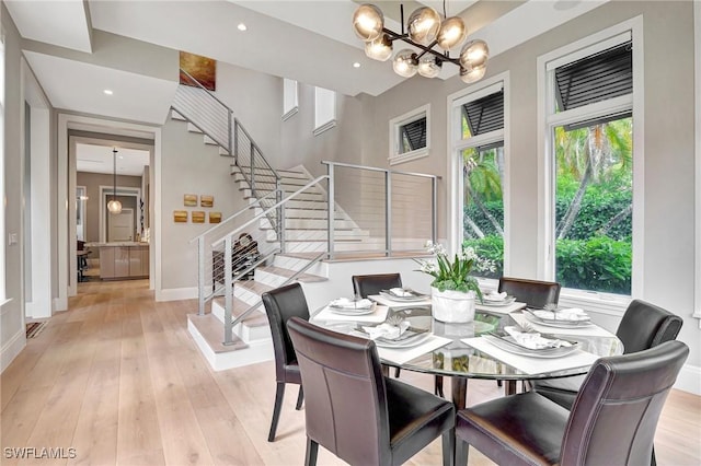 dining area with a notable chandelier and light hardwood / wood-style floors