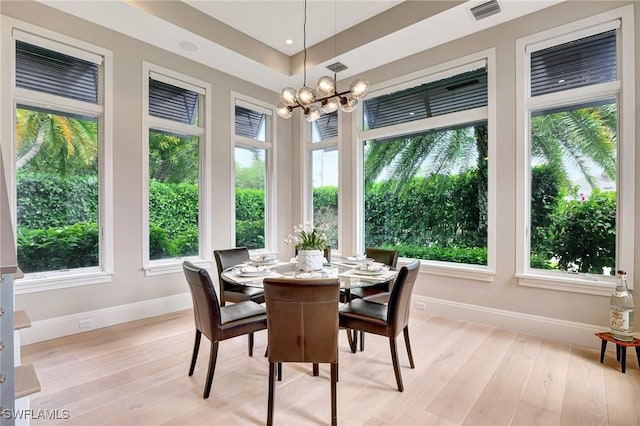 sunroom / solarium featuring a chandelier