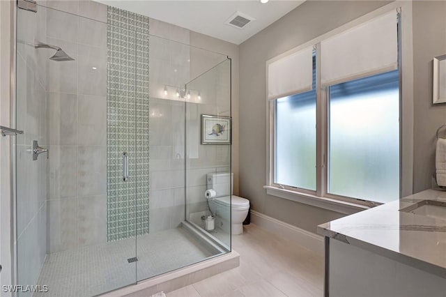 bathroom with vanity, tile patterned flooring, a shower with shower door, and toilet