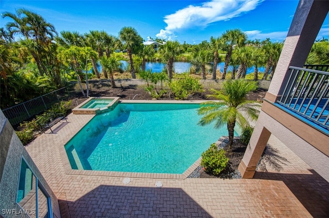 view of swimming pool with an in ground hot tub, a water view, and a patio