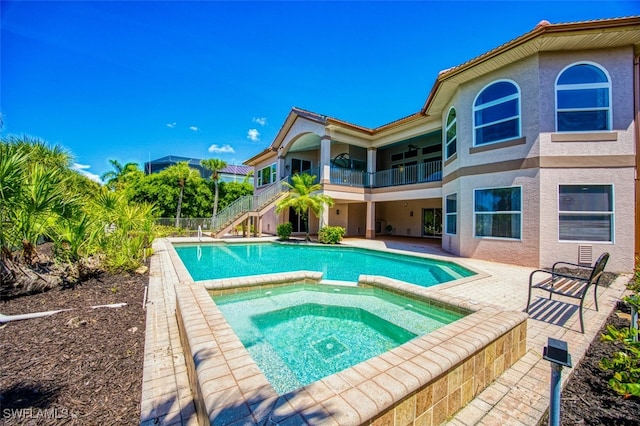 view of pool featuring a patio and an in ground hot tub