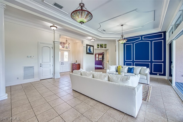 living room featuring decorative columns, crown molding, a raised ceiling, and light tile patterned floors