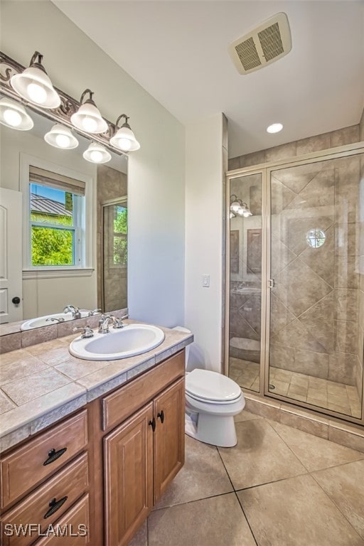 bathroom featuring vanity, tile patterned flooring, toilet, and walk in shower