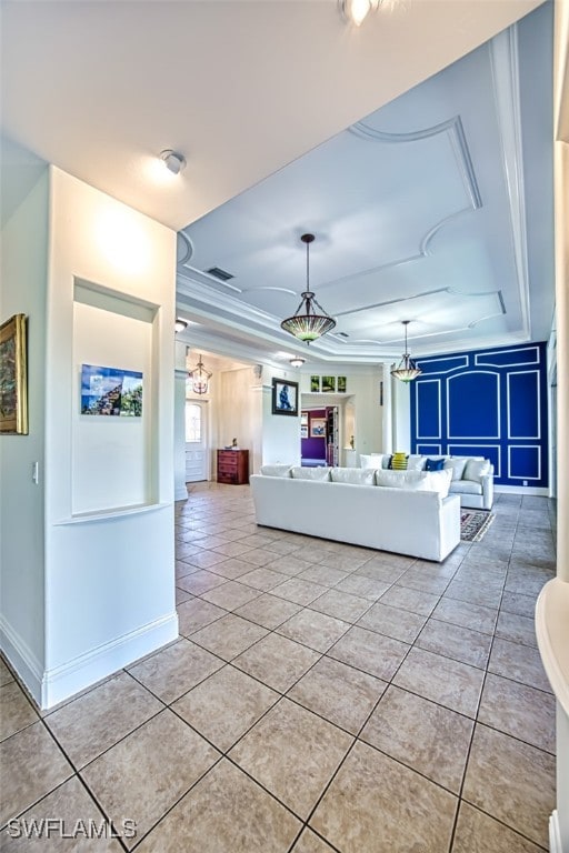 unfurnished living room featuring a tray ceiling and light tile patterned floors