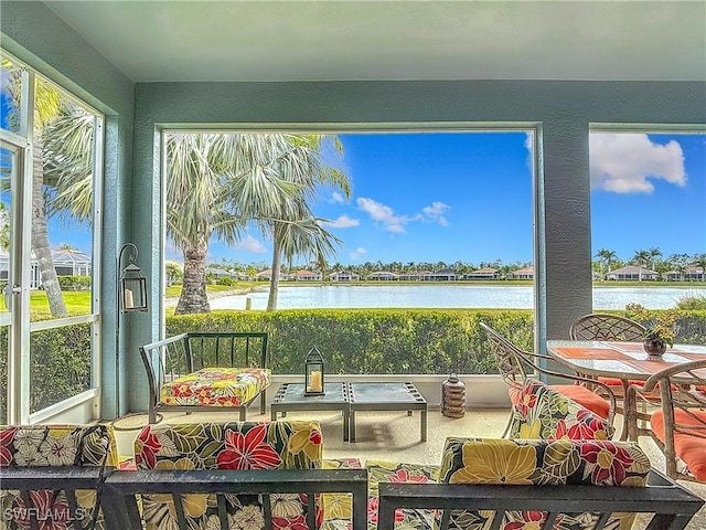 sunroom featuring a water view