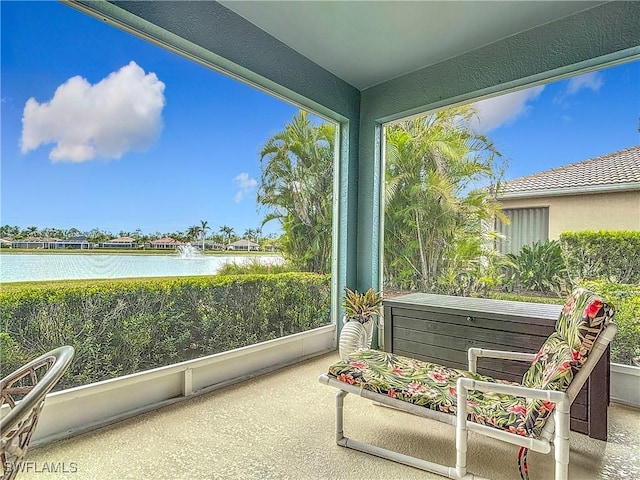 sunroom / solarium featuring a water view