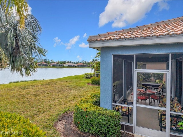 view of yard featuring a water view and a sunroom