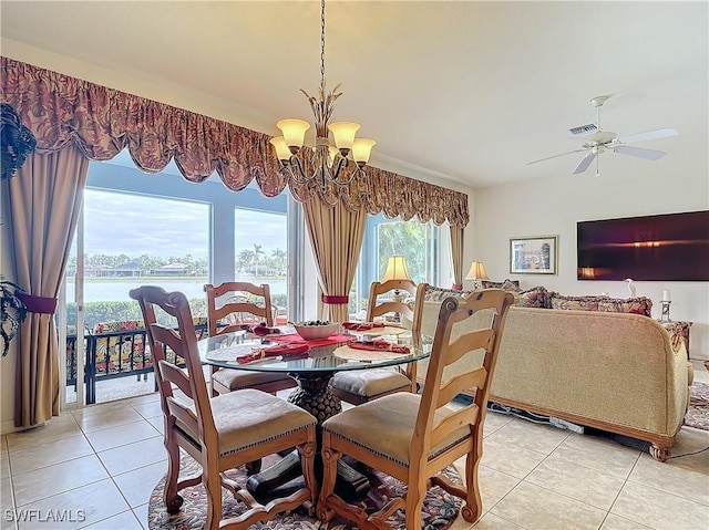 tiled dining space with ceiling fan with notable chandelier