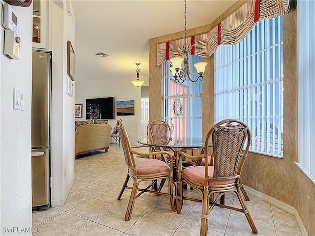 tiled dining space with an inviting chandelier