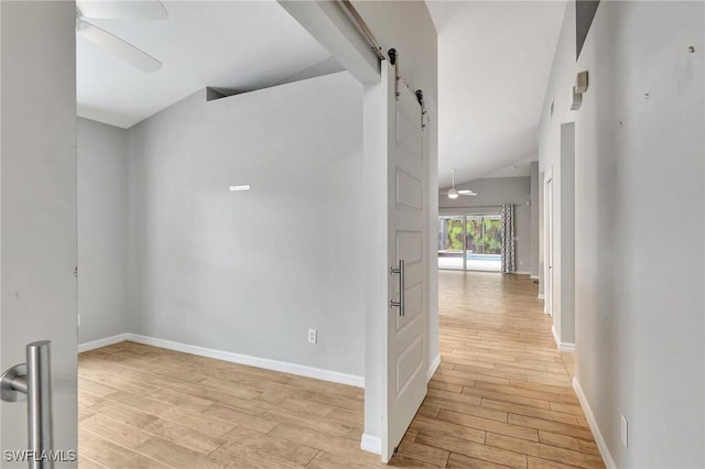 corridor featuring lofted ceiling and a barn door