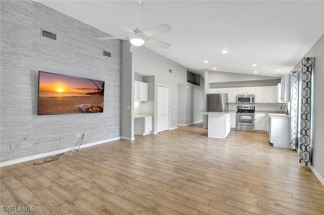 kitchen featuring white cabinetry, stainless steel appliances, a center island, high vaulted ceiling, and light hardwood / wood-style floors