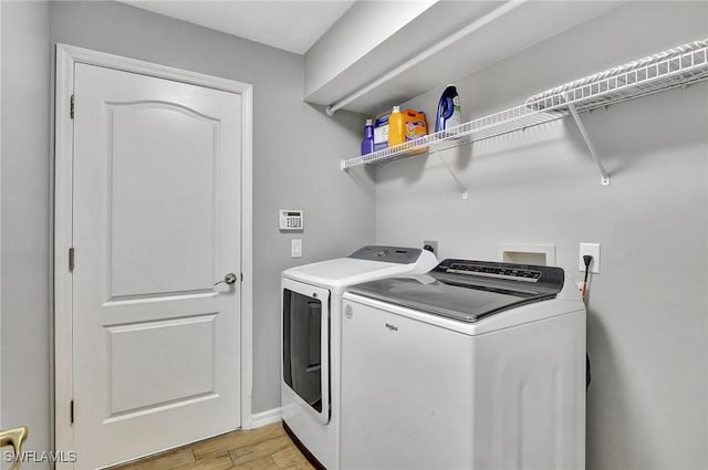 laundry room with washer and dryer and light wood-type flooring