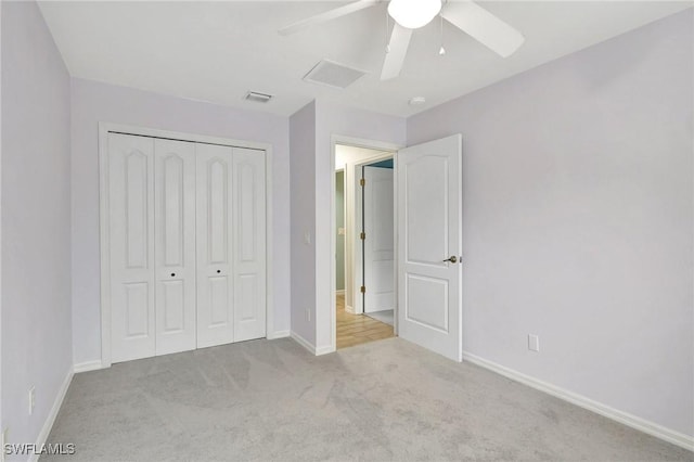 unfurnished bedroom featuring light colored carpet, ceiling fan, and a closet