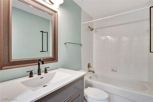 full bathroom featuring tiled shower / bath combo, vanity, and toilet