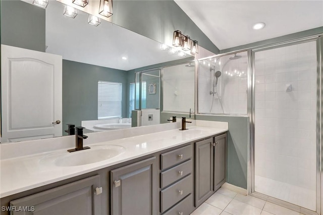 bathroom featuring vanity, a shower with shower door, tile patterned floors, and vaulted ceiling