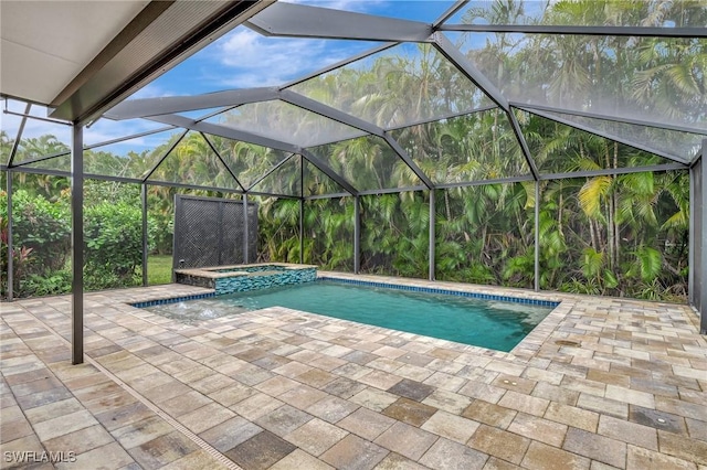 view of swimming pool featuring an in ground hot tub, glass enclosure, and a patio