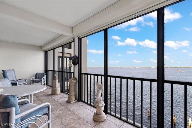 sunroom featuring a water view