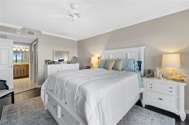 bedroom featuring crown molding, dark hardwood / wood-style floors, ceiling fan, and ensuite bath