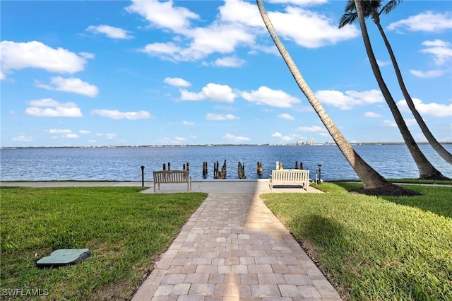 dock area with a water view and a yard