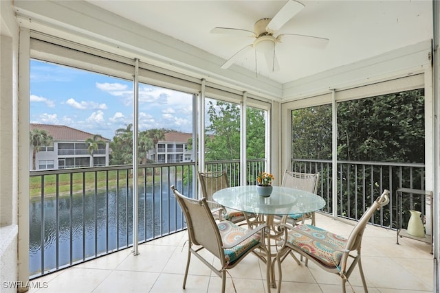 sunroom with a water view and ceiling fan