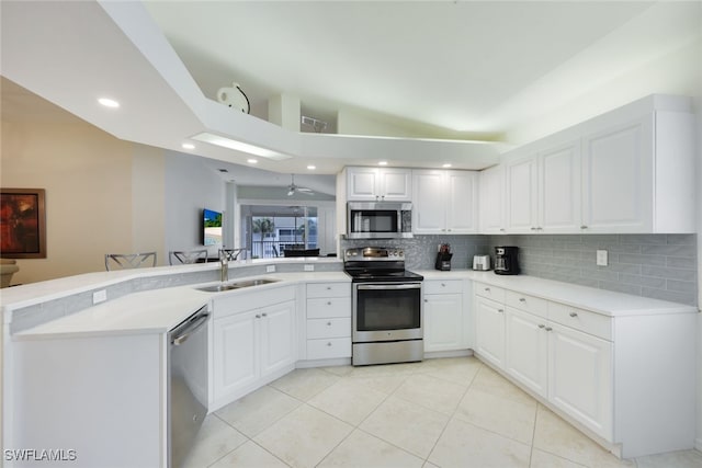 kitchen with a sink, stainless steel appliances, light countertops, and white cabinets