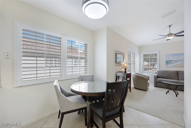 dining area with light tile patterned floors, ceiling fan, light carpet, and baseboards