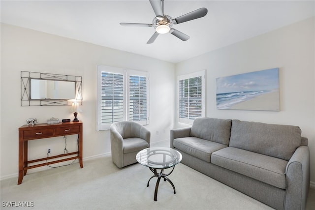 living area featuring a ceiling fan, light colored carpet, and baseboards