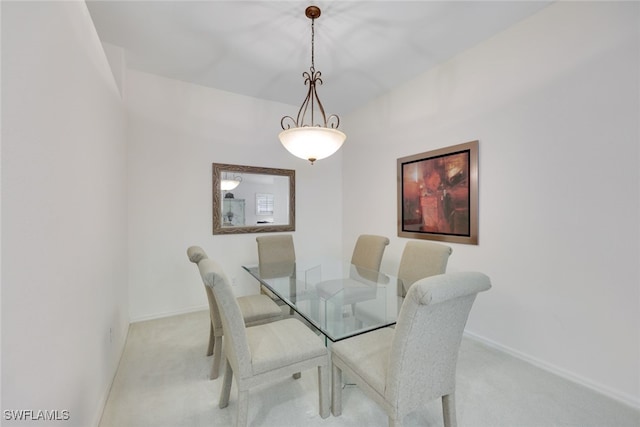 dining room featuring light colored carpet and baseboards