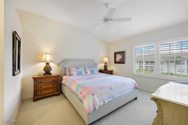 bedroom with lofted ceiling, light carpet, and baseboards