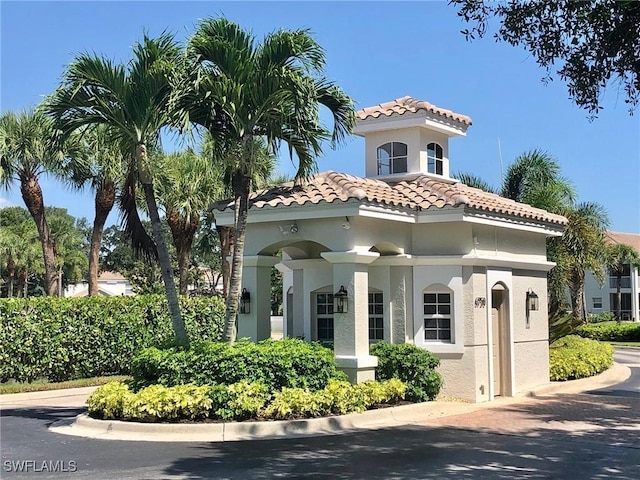 mediterranean / spanish house with a tiled roof and stucco siding