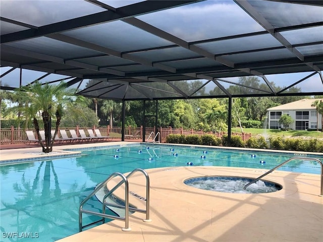 community pool with glass enclosure, fence, a community hot tub, and a patio