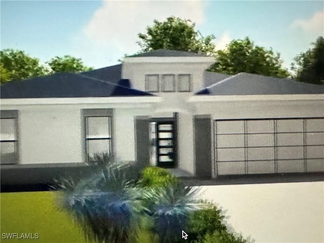 view of front of home with a garage and stucco siding