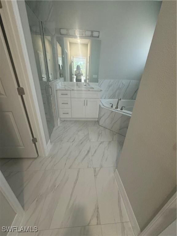543 Mcarthur Blvd, Lehigh Acres, FL 33974 - bathroom with vanity, marble look tile flooring, and a garden tub